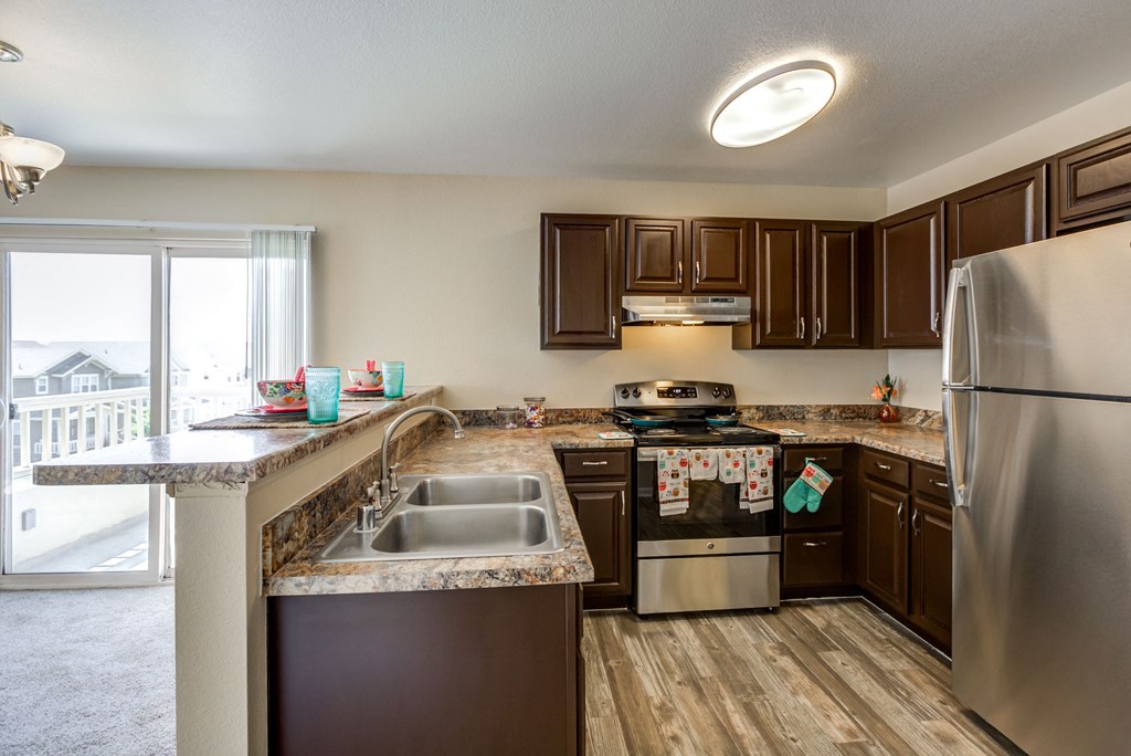 an updated kitchen with stainless steel appliances and granite counter tops