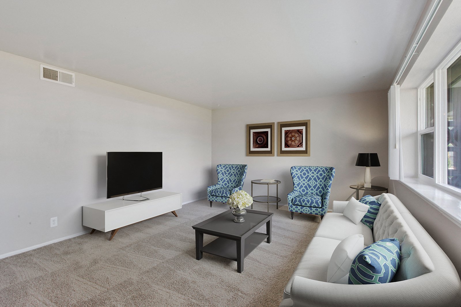 A living room with a white couch and a television.