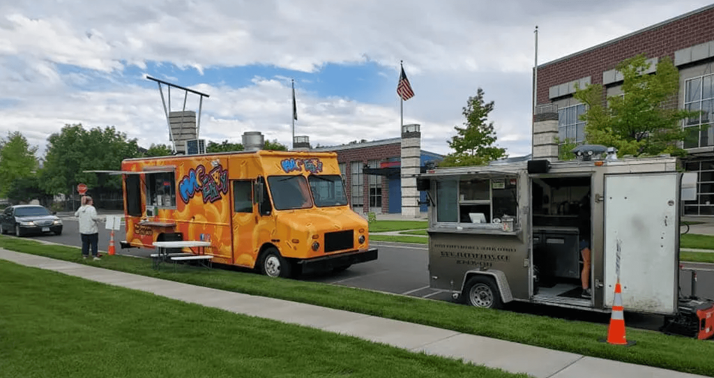 two food trucks parked in front of a building