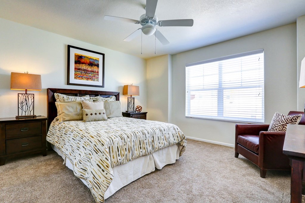 a bedroom with a large bed and a ceiling fan