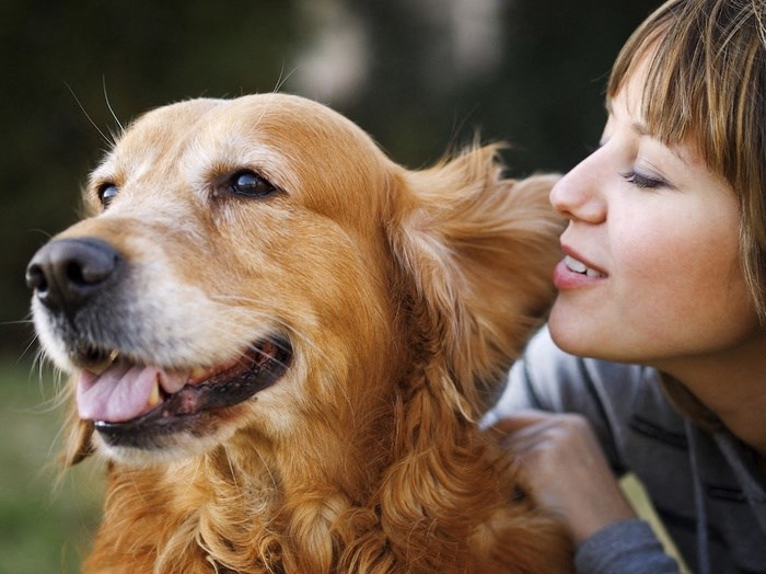 a woman and a dog looking at each other