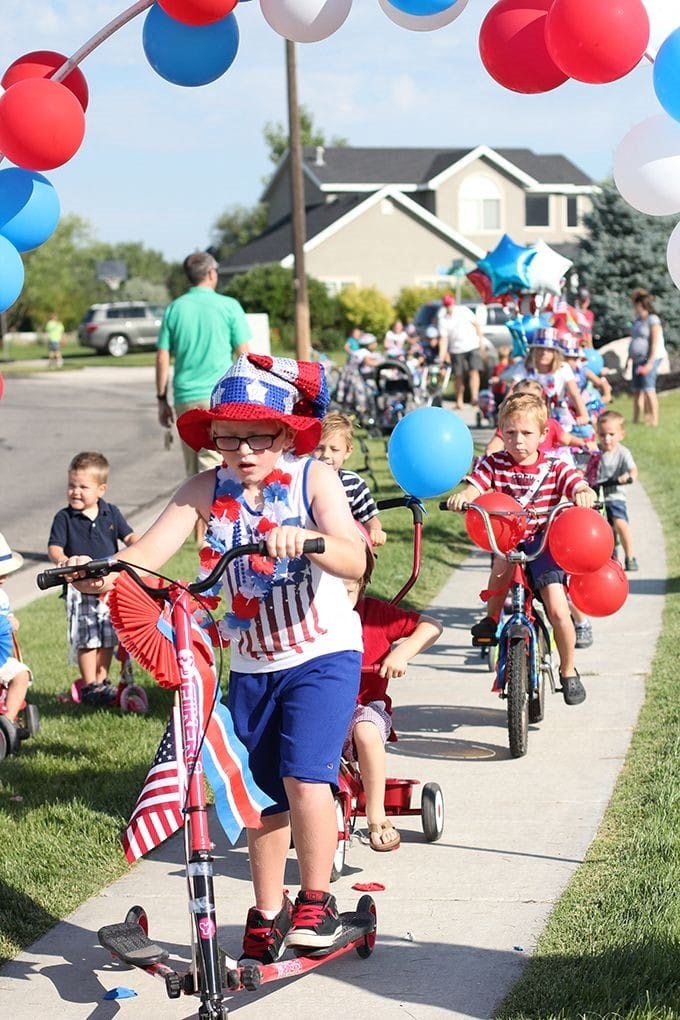 a group of children riding bikes down a sidewalk