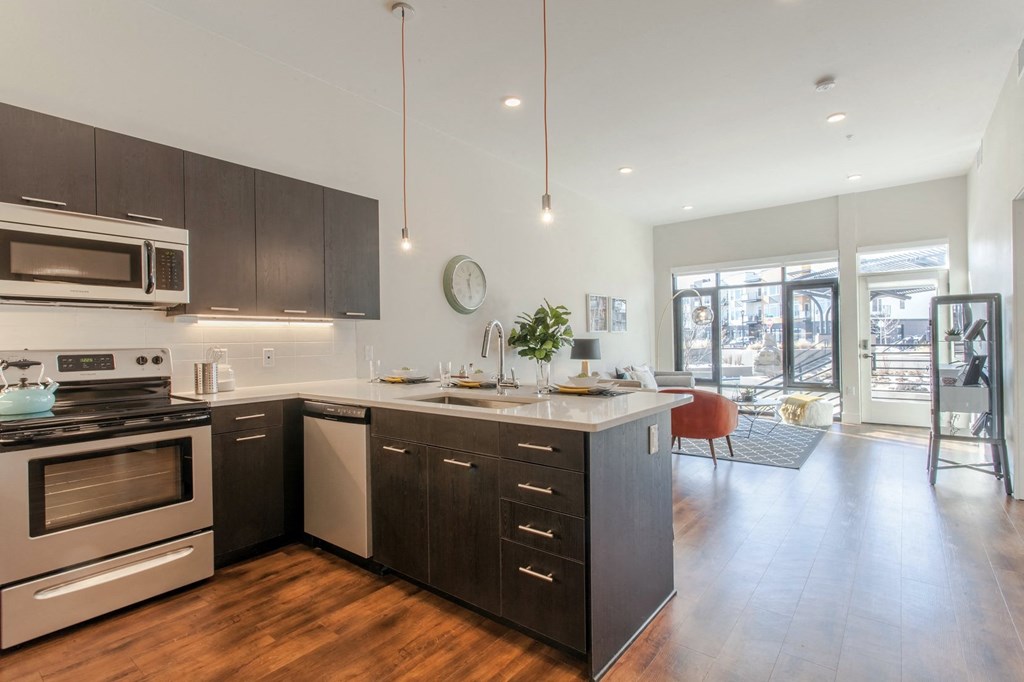Living room and kitchen with wood flooringat Delo Apartments, Louisville, Colorado