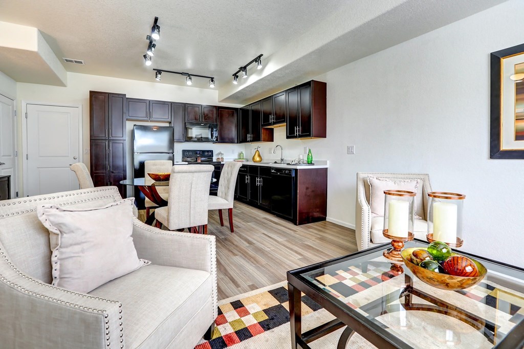 our apartments offer a living room with a couch a coffee table and a kitchen with a breakfast
