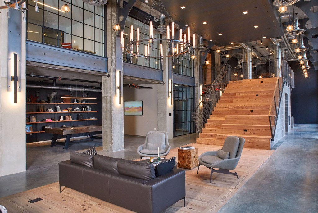 the lobby of a building with couches and chairs and a staircase