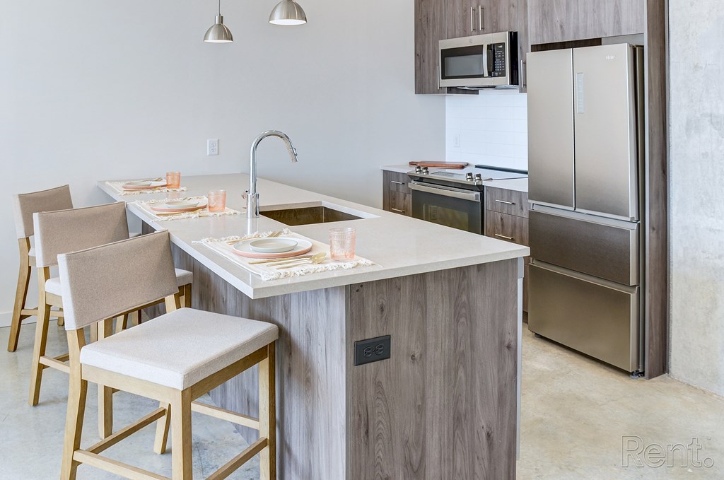 A kitchen with a white countertop and wooden cabinets at The Anthem at Square 10 Apartments, New Haven, CT, 06510