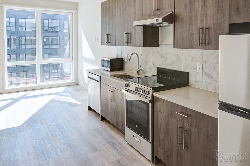 A kitchen with a stove top oven and a microwave at The Anthem at Square 10 Apartments, New Haven, 06510