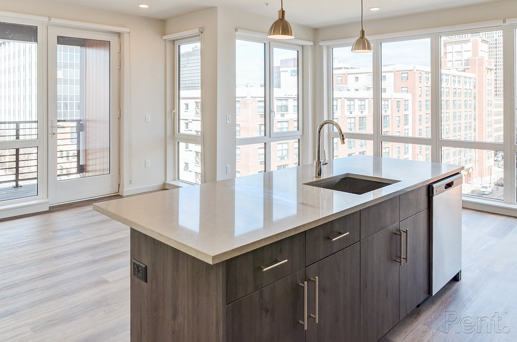 A modern kitchen with a large island and wooden cabinets at The Anthem at Square 10 Apartments, New Haven, CT