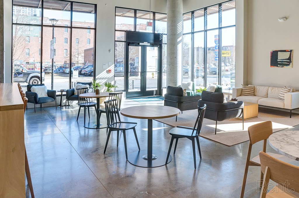 A large room with tables and chairs and a view of the street outside at The Anthem at Square 10 Apartments, Connecticut