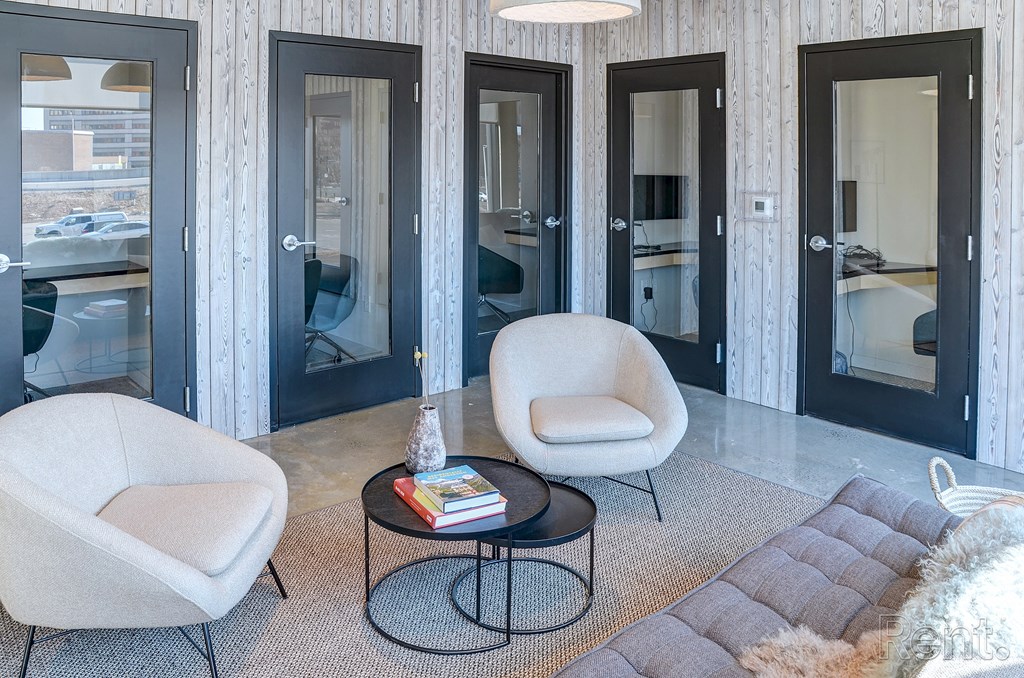 A living room with a grey sofa, a white chair and a coffee table at The Anthem at Square 10 Apartments, New Haven, 06510