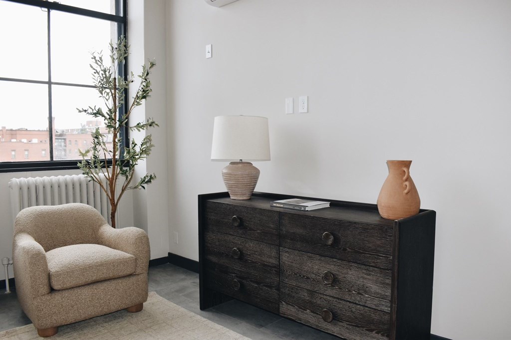 A room with a chair, a dresser, and a lamp. at The 55 Elm Club Apartments, Connecticut