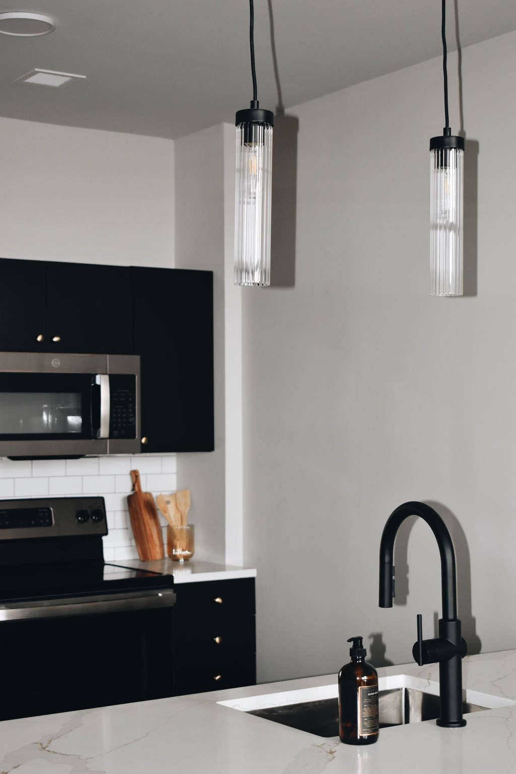 A modern kitchen with black cabinets and a white countertop. at The 55 Elm Club Apartments, Hartford, Connecticut