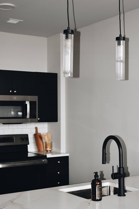 A modern kitchen with black cabinets and a white countertop.