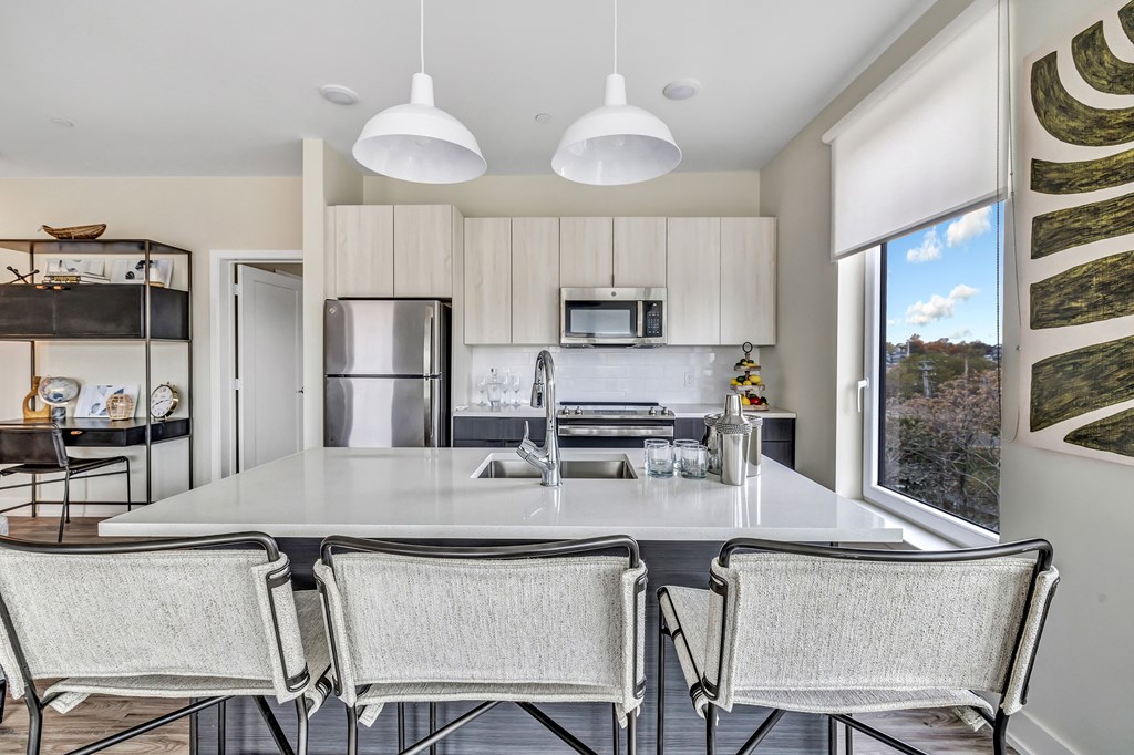 a kitchen with a large island and chairs