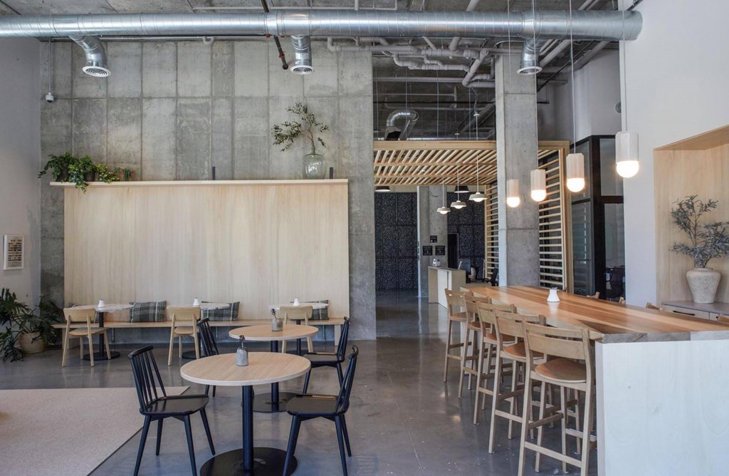 A modern dining area with wooden tables and chairs at The Anthem at Square 10 Apartments, New Haven, Connecticut