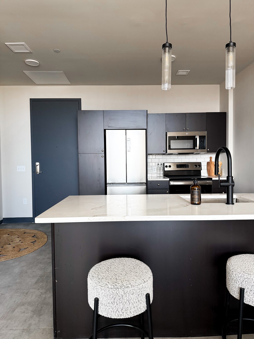 A kitchen with a white countertop and black cabinets. at The 55 Elm Club Apartments, Hartford 06106