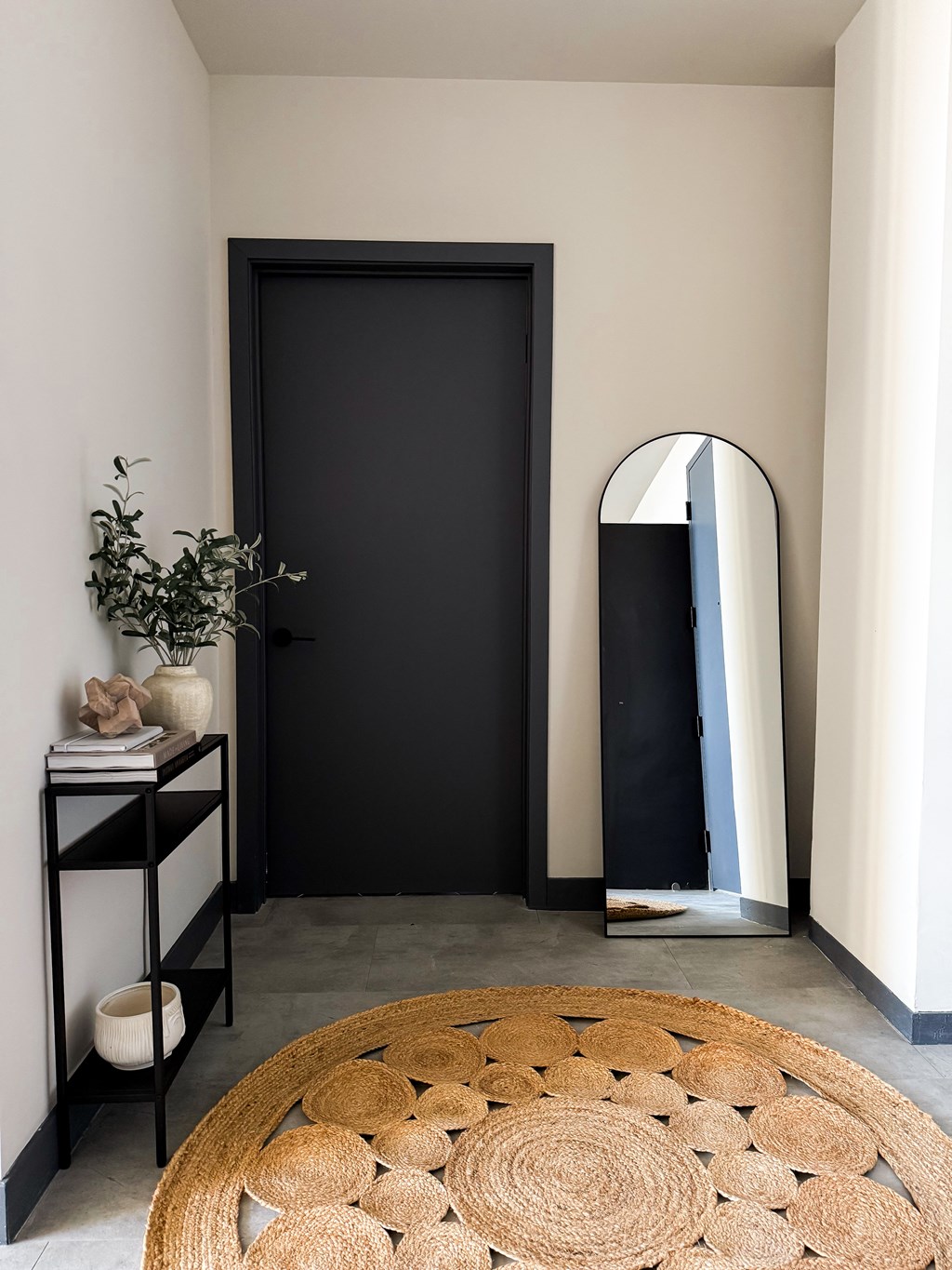 A black door is in a room with a round rug in front of it. at The 55 Elm Club Apartments, Hartford, CT