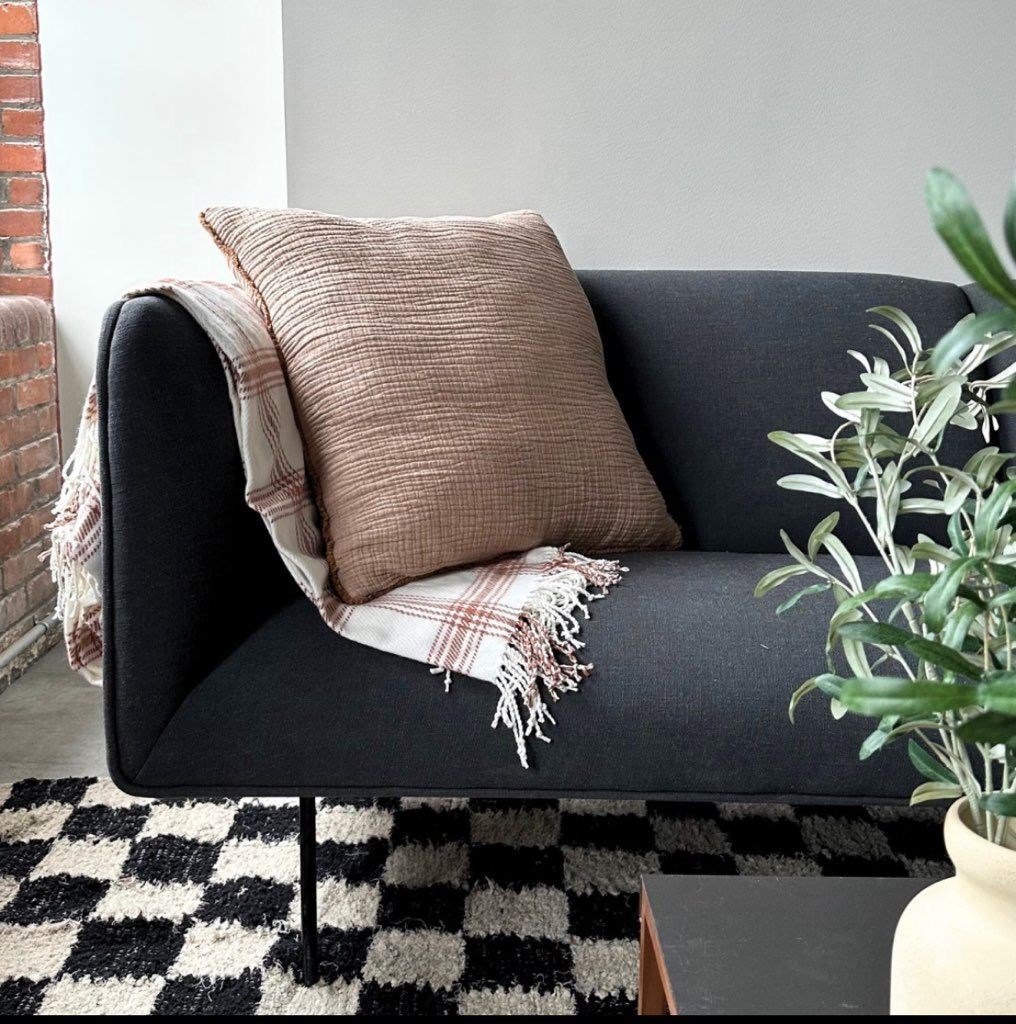 a black couch with a pillow and a blanket on it at The 55 Elm Club Apartments, Hartford, CT, 06106