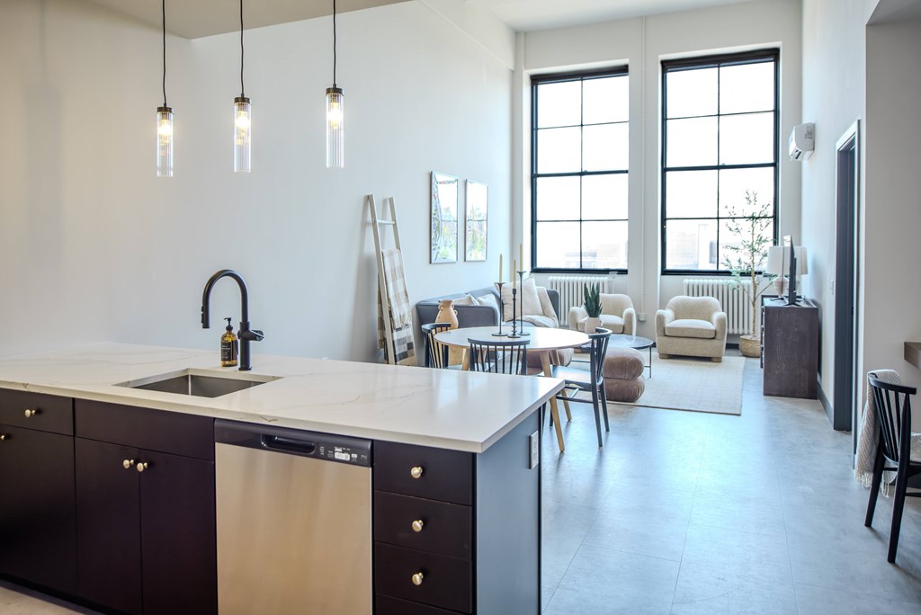 A modern kitchen with a large island and pendant lights.