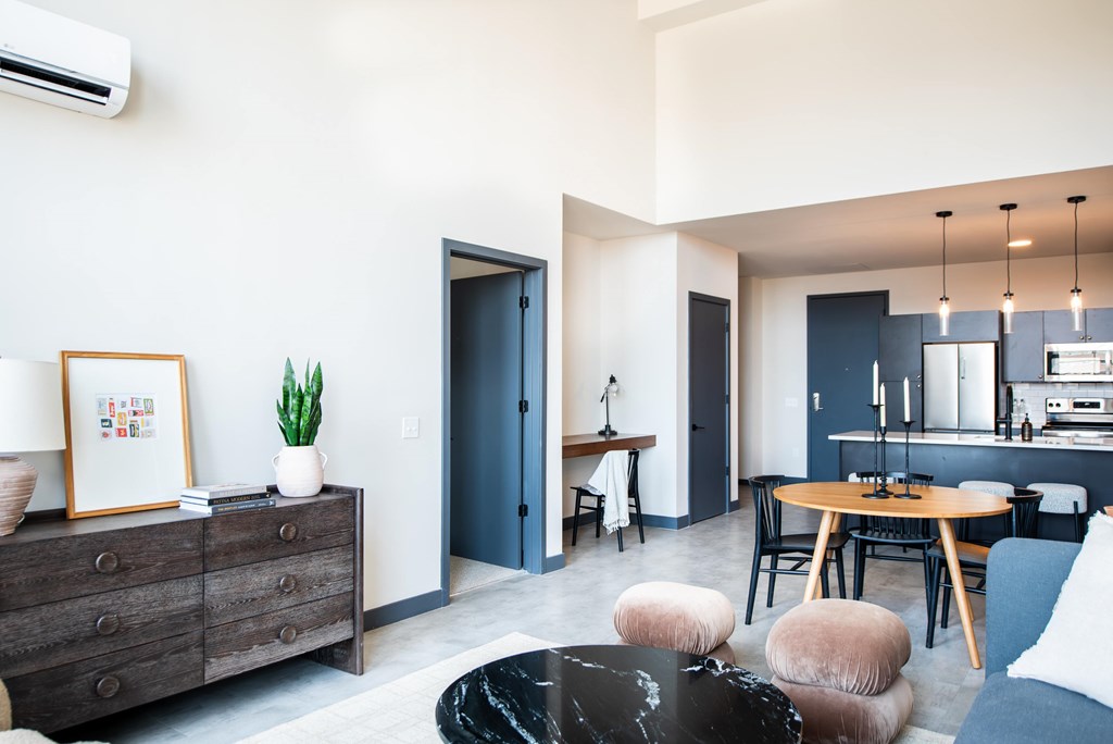 A modern living room with a black coffee table and a grey sofa.