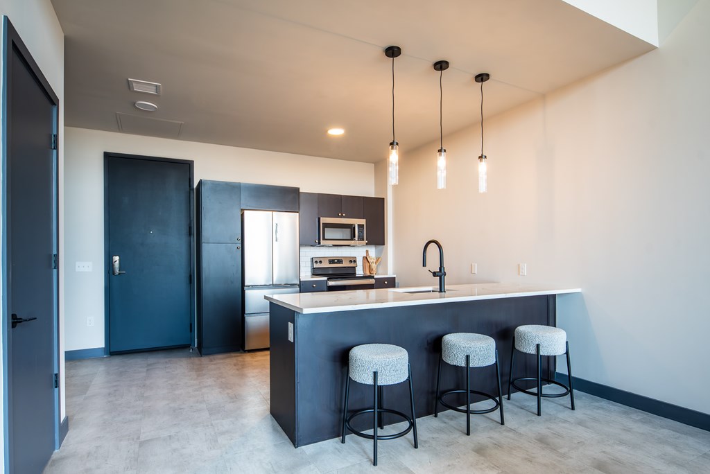 A kitchen with a bar stool and a kitchen island.