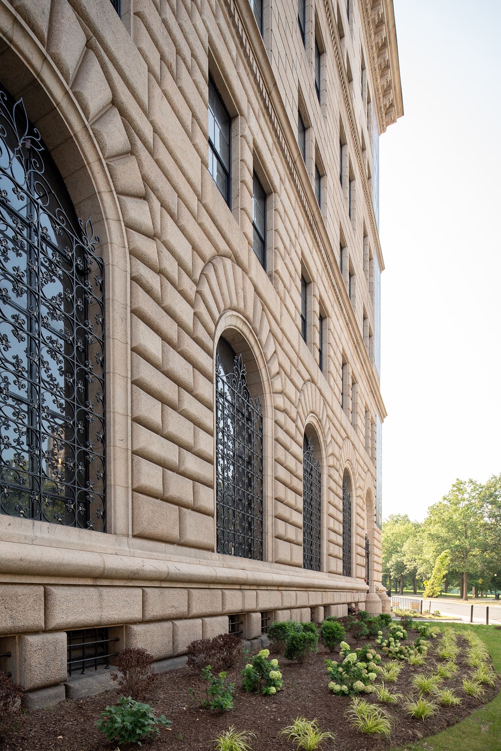 A large building with a lot of windows and a garden in front.