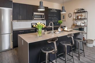 a kitchen with a large center island with three stools  at Iron Works Sono, Norwalk, Connecticut - Photo Gallery 5