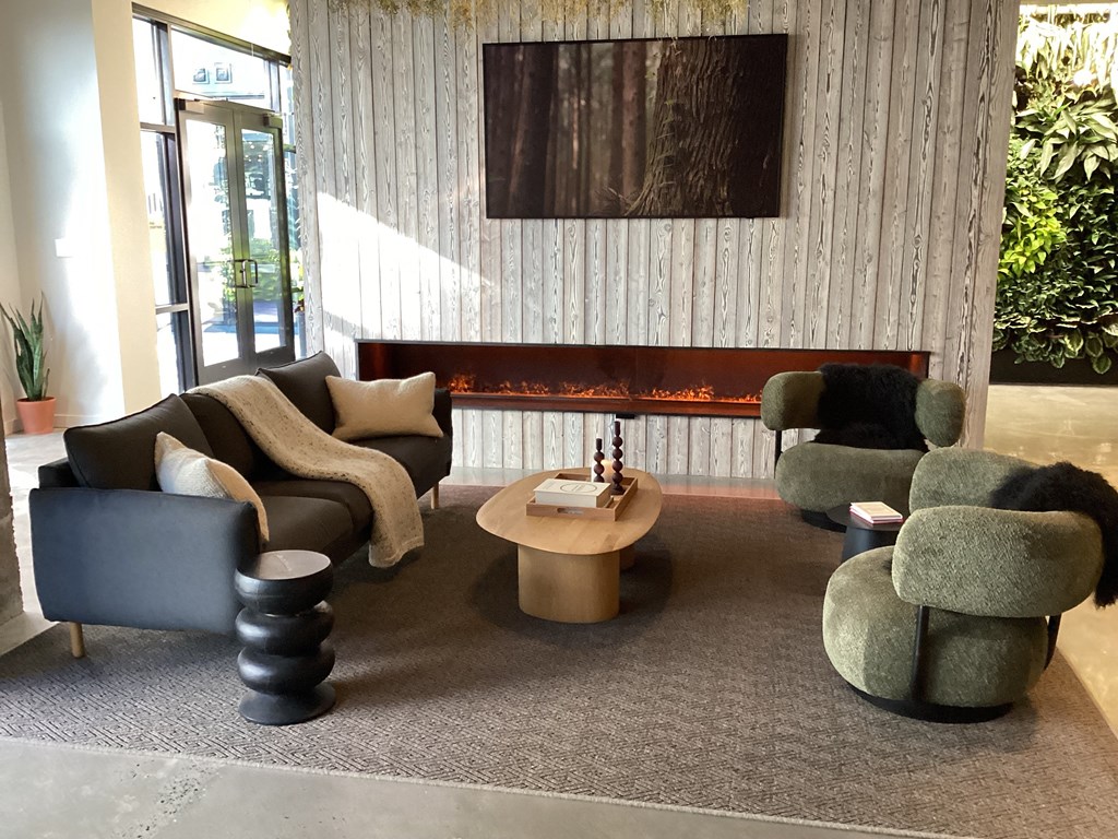 A living room with a grey carpet and a wooden wall at The Anthem at Square 10 Apartments, New Haven, CT