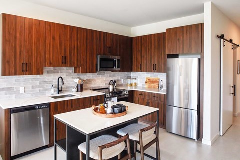A kitchen with a table and chairs in the middle of it.