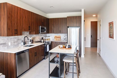 A kitchen with wooden cabinets and a white counter top.