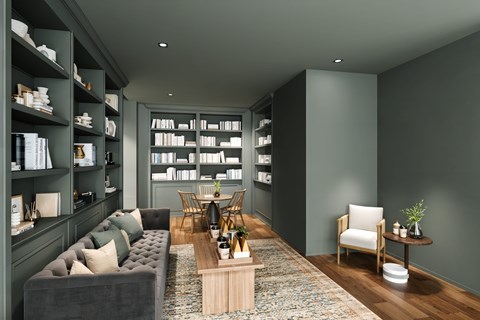 A modern living room with a grey sofa, a wooden coffee table, and a bookshelf filled with books.