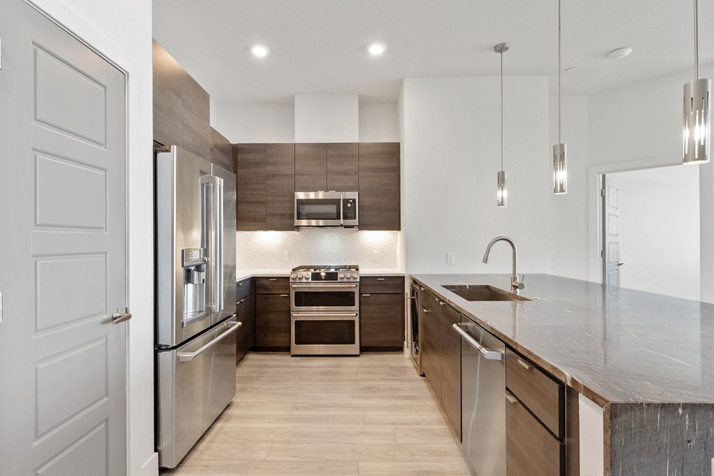 a modern kitchen with stainless steel appliances and wooden cabinets