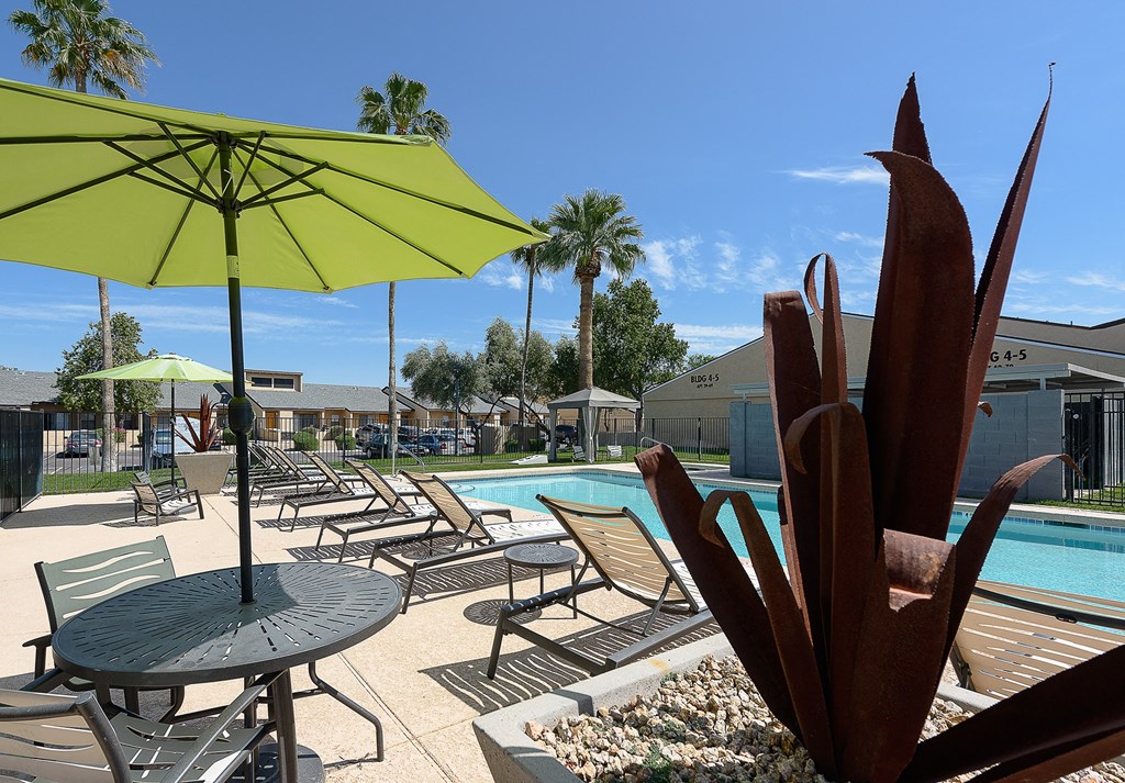 a swimming pool with chaise lounge chairs and an umbrella