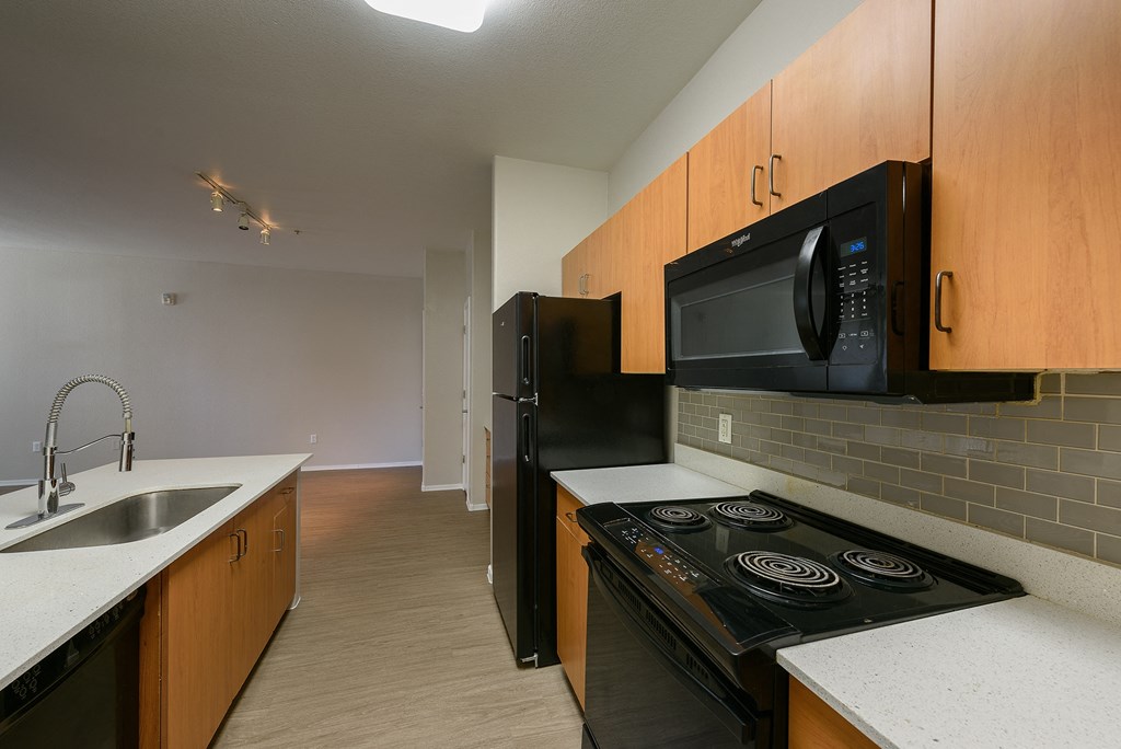 a kitchen with black appliances and wooden cabinets