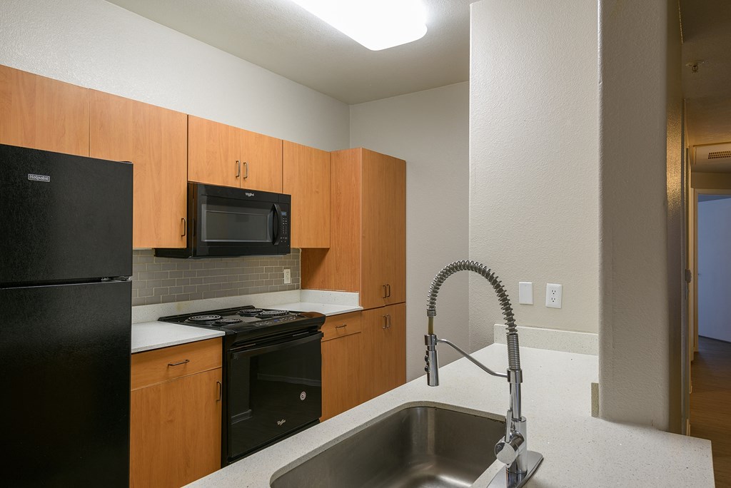 a kitchen with black appliances and white countertops