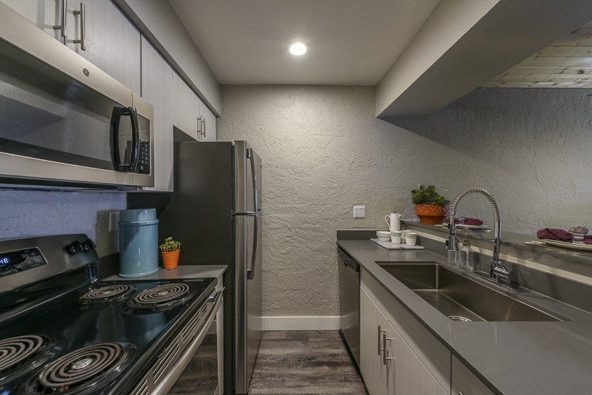 a kitchen with a sink stove refrigerator and microwave