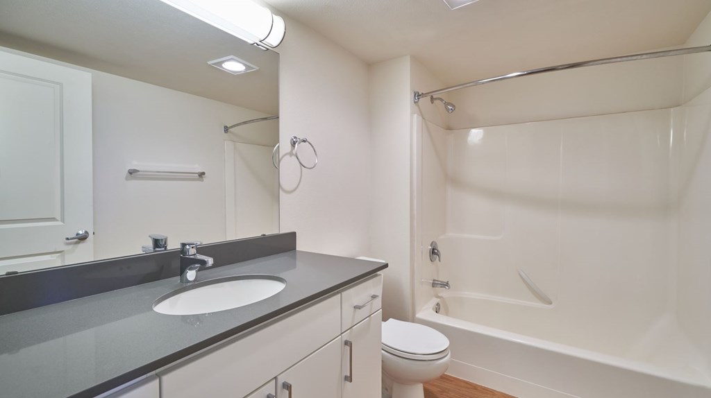 A white bathroom with a sink, toilet, and bathtub.