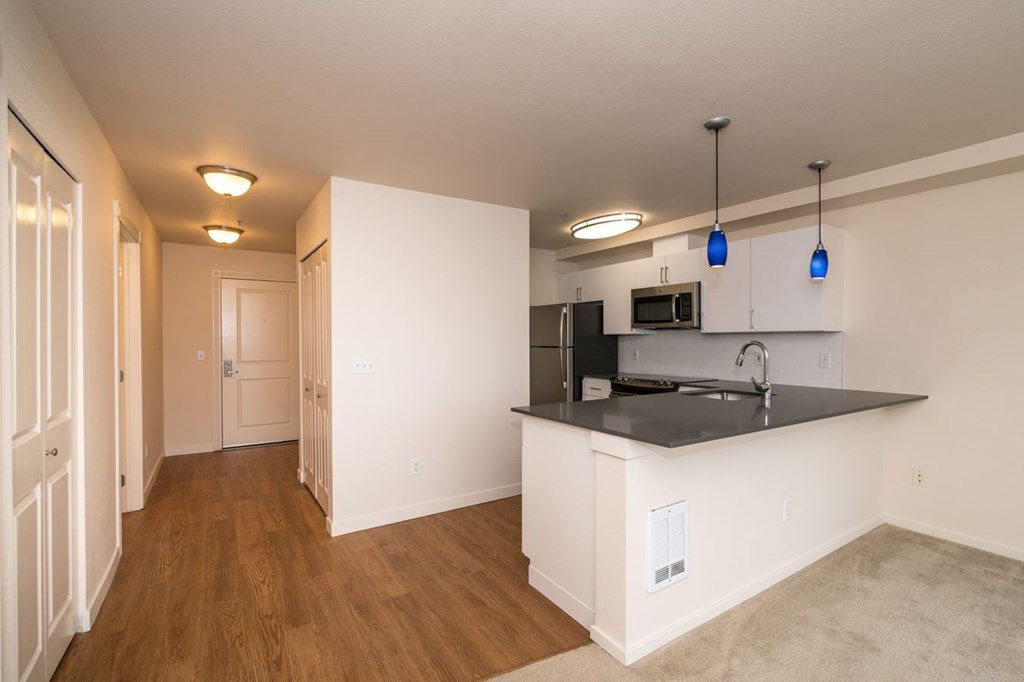 A kitchen with a black counter top and white cabinets.