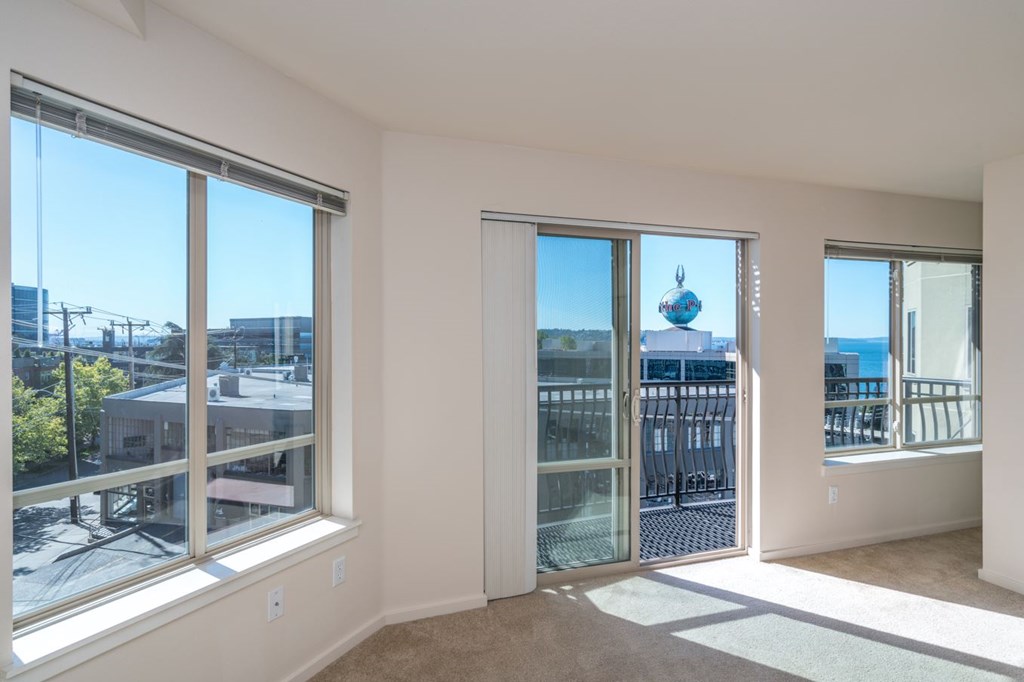 A room with a view of the city through large windows.