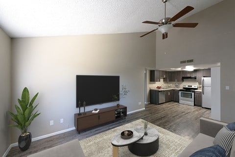 an open living room with a large tv and a kitchen