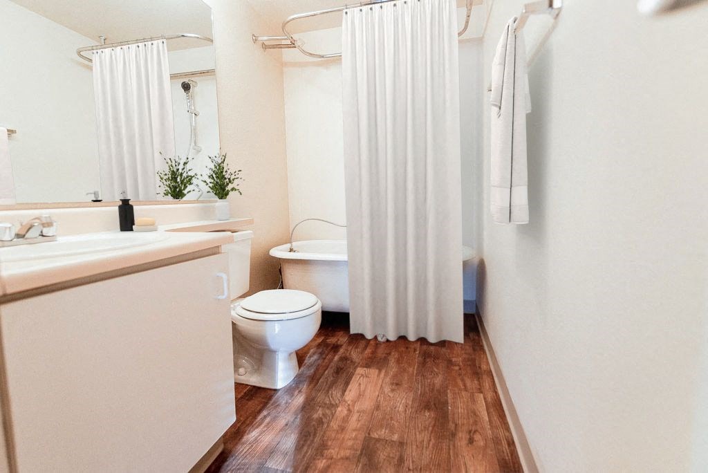 a bathroom with a toilet and a shower curtain at Zindorf, Seattle, WA, 98104