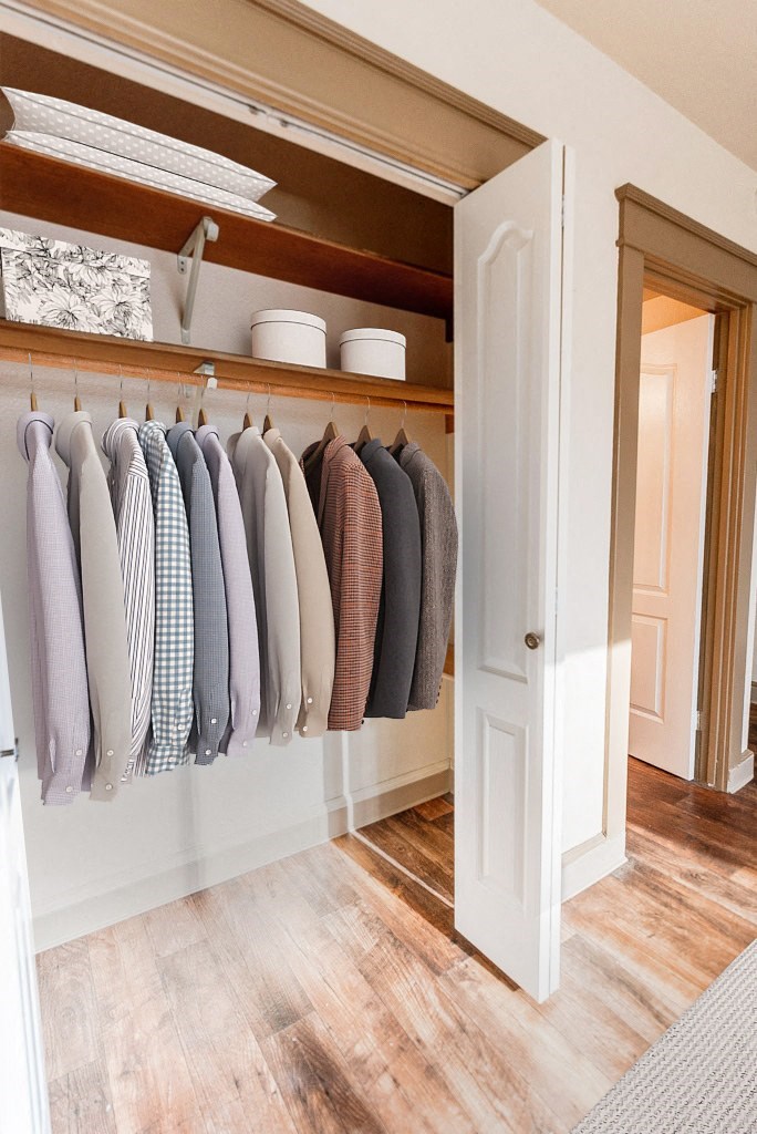 a closet with clothes hanging on a rack and a door to the bathroom at Zindorf, Seattle, Washington