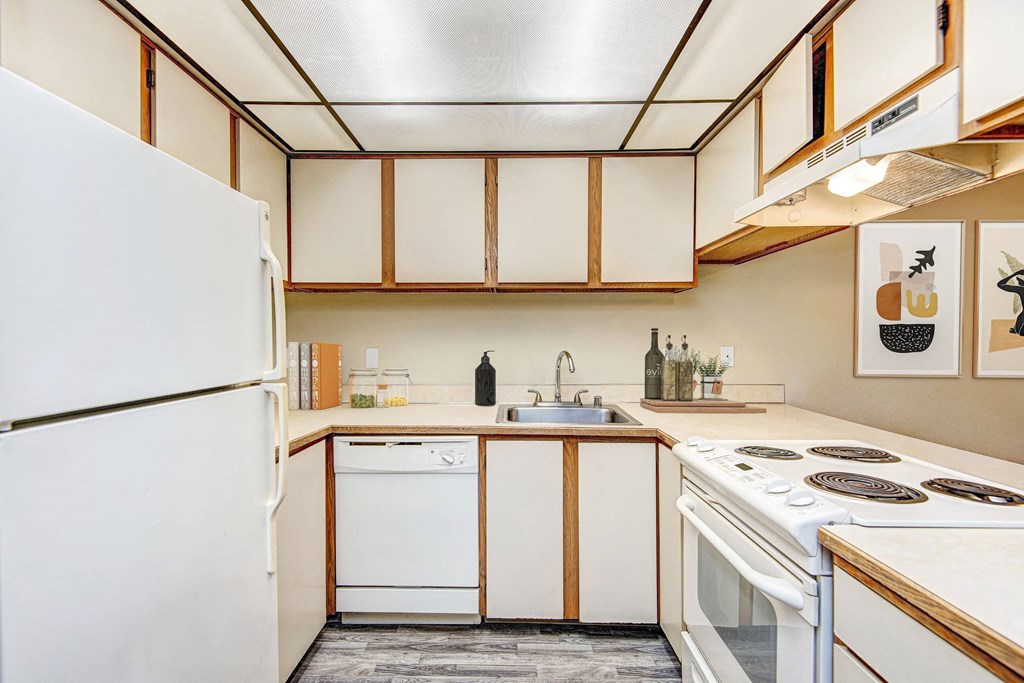 A kitchen with white appliances and wooden cabinets. at Autumn Village, Washington, 98354