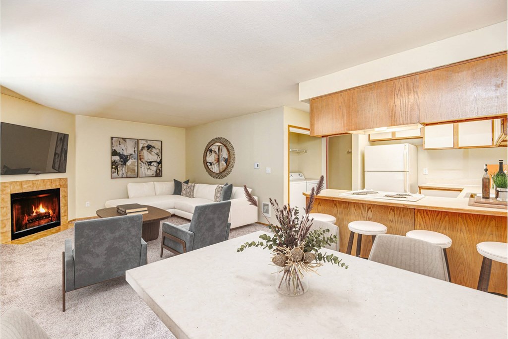 A living room with a fireplace and a dining table. at Autumn Village, Washington