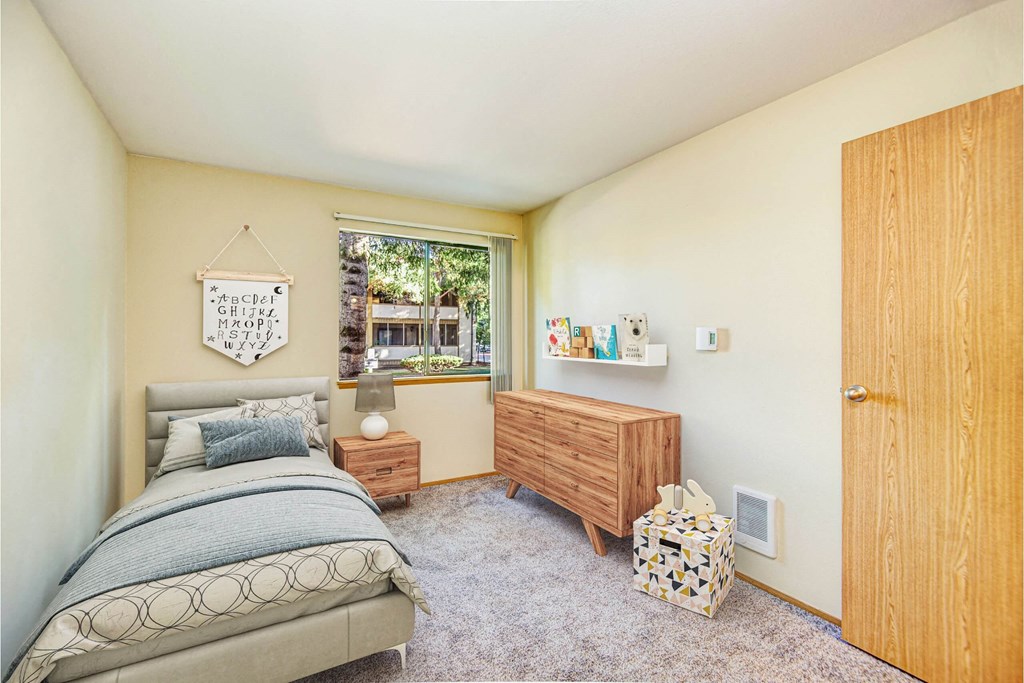 A bedroom with a bed, nightstand, and a window. at Autumn Village, Washington, 98354