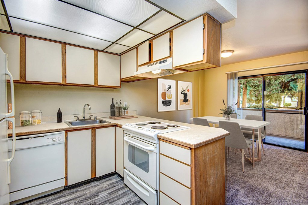 A kitchen with white appliances and wooden cabinets. at Autumn Village, Milton, WA, 98354