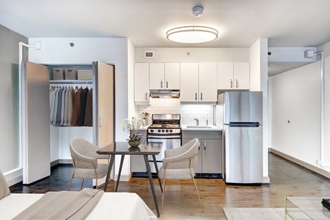 A modern kitchen with a table and chairs in the middle.