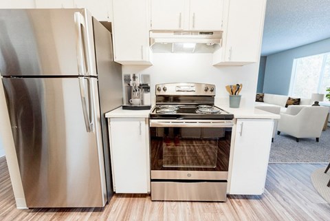 A modern kitchen with a stainless steel refrigerator and a white island with a stove.