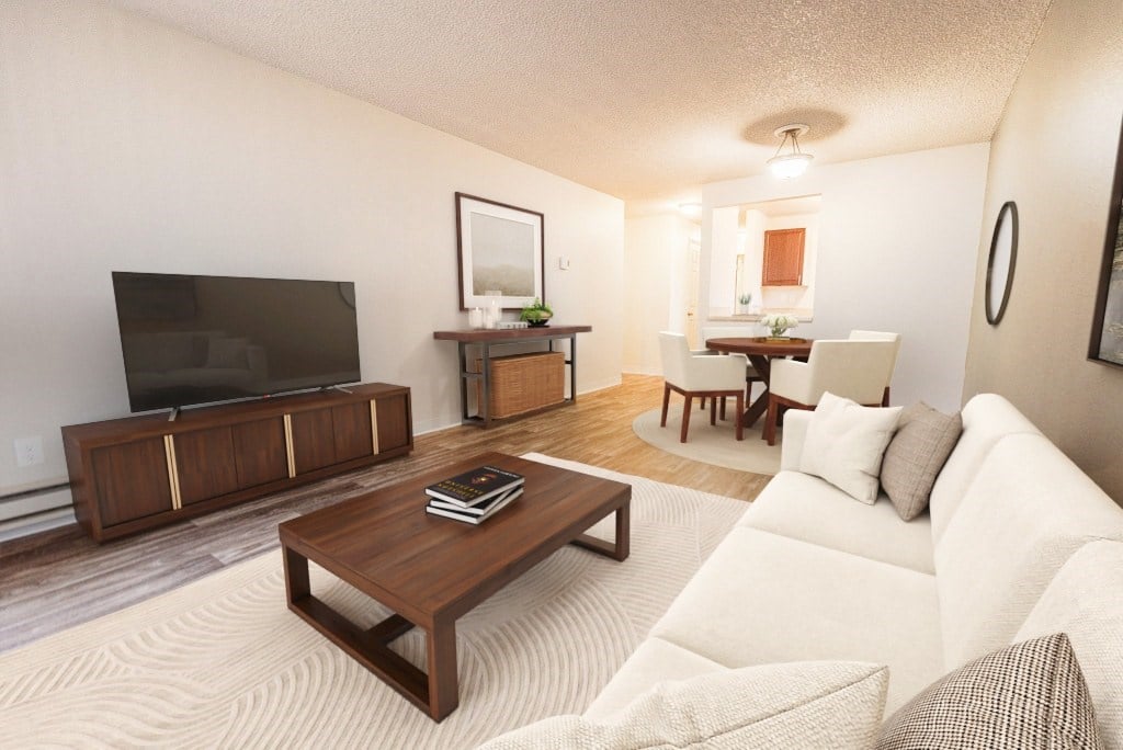 A living room with a white couch and a wooden coffee table.