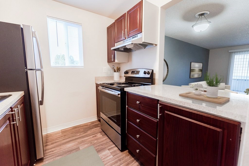 A kitchen with a refrigerator, oven, and sink.